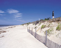 Photo of a beach with scenis lighthouse in the distance
